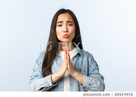 Lifestyle, people emotions and beauty concept. Silly and cute pleading asian girl begging for favour or apology, grimacing looking sad eyes, hold hands in pray as need help, white background Lifestyle, people emotions and beauty concept. Silly and cute pleading asian girl begging for favour or apology, grimacing looking sad eyes, hold hands in pray as need help, white background 80924958