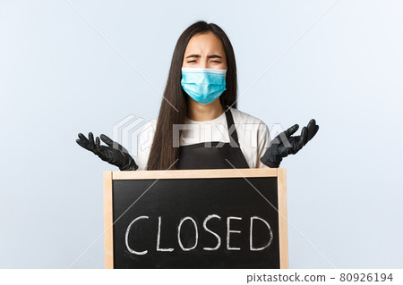 Small business, covid-19 pandemic, preventing virus and employees concept. Upset desperate cafe owner left without work and business during lockdown, crying over closed sign Small business, covid-19 pandemic, preventing virus and employees concept. Upset desperate cafe owner left without work and business during lockdown, crying over closed sign 80926194