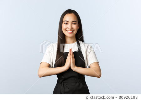 Coffee shop, small business and startup concept. Young smiling asian female cafe employee, staff at restaurant hope everyone staying safe on quarantine, praying with hands in plead gesture 80926198