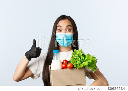 Covid-19, grocery store, employment, small business and preventing virus concept. Ccheerful shop employee, cashier in medical mask and gloves provide safe shopping during coronavirus, thumb-up Covid-19, grocery store, employment, small business and preventing virus concept. Ccheerful shop employee, cashier in medical mask and gloves provide safe shopping during coronavirus, thumb-up 80926284