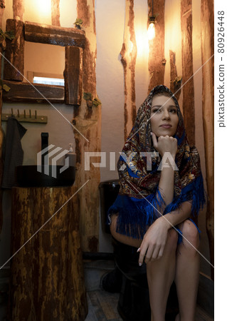 Young woman sitting in rustic style toilet room Young woman sitting in rustic style toilet room 80926448