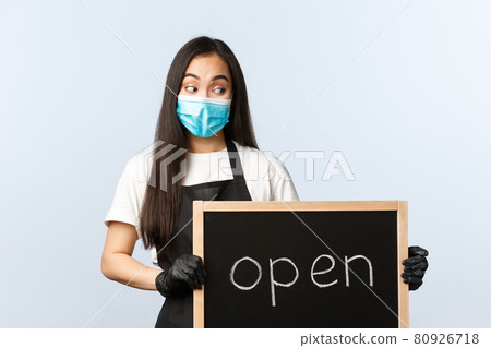 Small business, covid-19 pandemic, preventing virus and employees concept. Smiling cute asian female employee, cafe or store worker holding open sign, invite visitors Small business, covid-19 pandemic, preventing virus and employees concept. Smiling cute asian female employee, cafe or store worker holding open sign, invite visitors 80926718