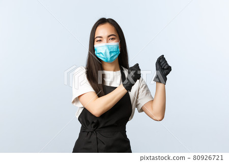 Covid-19, social distancing, small coffee shop business and preventing virus concept. Happy smiling asian barista, female cafe employee dancing anticipating visitors, wear medical mask and gloves Covid-19, social distancing, small coffee shop business and preventing virus concept. Happy smiling asian barista, female cafe employee dancing anticipating visitors, wear medical mask and gloves 80926721