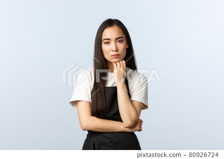 Coffee shop, small business and startup concept. Serious-looking thoughtful asian girl cafe owner thinking, hold fist under chin and stare camera as listening, standing white background Coffee shop, small business and startup concept. Serious-looking thoughtful asian girl cafe owner thinking, hold fist under chin and stare camera as listening, standing white background 80926724