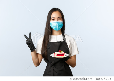 Covid-19, social distancing, small coffee shop and preventing virus concept. Cheerful smiling asian cafe owner, employee in medical mask show peace sign, take care of visitor health, give cake Covid-19, social distancing, small coffee shop and preventing virus concept. Cheerful smiling asian cafe owner, employee in medical mask show peace sign, take care of visitor health, give cake 80926793