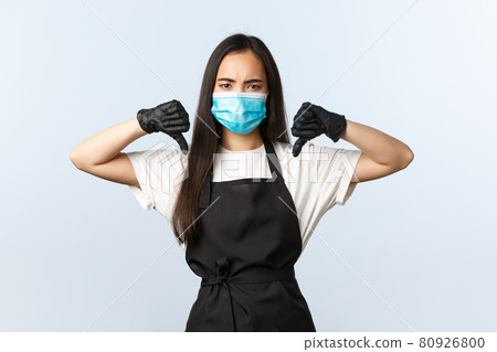 Covid-19, social distancing, small coffee shop business and preventing virus concept. Disappointed asian cafe staff, barista in medical mask and gloves show thumb-down Covid-19, social distancing, small coffee shop business and preventing virus concept. Disappointed asian cafe staff, barista in medical mask and gloves show thumb-down 80926800