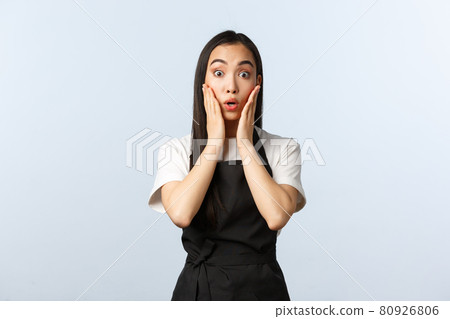 Coffee shop, small business and startup concept. Surprised asian girl barista in black apron, gasping in amazement, touch cheeks and stare camera astonished. Female cafe owner react to news Coffee shop, small business and startup concept. Surprised asian girl barista in black apron, gasping in amazement, touch cheeks and stare camera astonished. Female cafe owner react to news 80926806