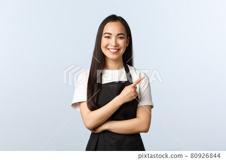Coffee shop, small business and startup concept. Cheerful asian girl in apron working restaurant or cafe, inviting consumers for special offer. Smiling female staff pointing finger right Coffee shop, small business and startup concept. Cheerful asian girl in apron working restaurant or cafe, inviting consumers for special offer. Smiling female staff pointing finger right 80926844