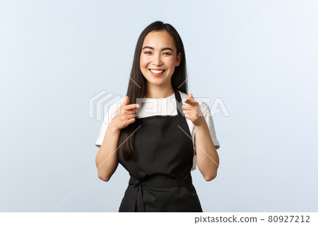 Coffee shop, small business and startup concept. Cheerful smiling female barista, asian cafe staff in black apron pointing at camera, inviting consumers visit and try new desserts, white background Coffee shop, small business and startup concept. Cheerful smiling female barista, asian cafe staff in black apron pointing at camera, inviting consumers visit and try new desserts, white background 80927212