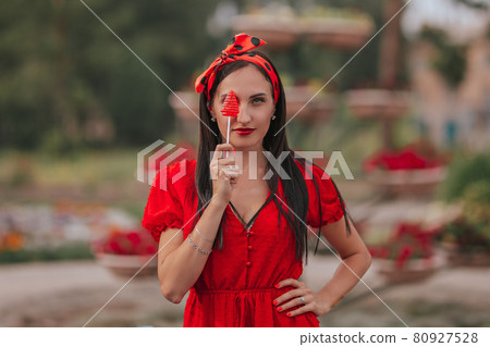 Fashion portrait of sexy young woman in red clothes with lolipop in her hand 80927528