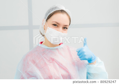 portrait of positive female doctor in mask and medical cap 80929247