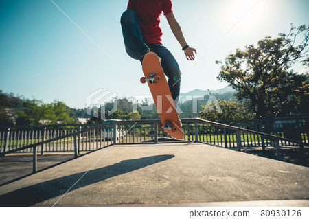Asian woman skateboarder skateboarding at skatepark Asian woman skateboarder skateboarding at skatepark 80930126
