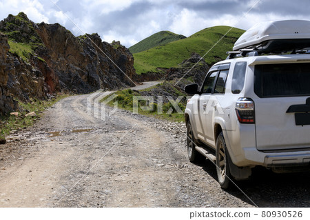 Driving off road car on high altitude mountain top Driving off road car on high altitude mountain top 80930526