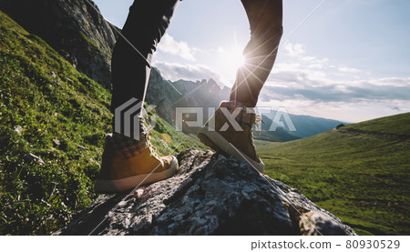 Successful woman backpacker hiking on sunset alpine mountain peak 80930529