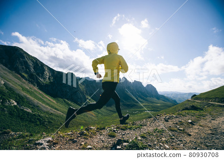Woman ultramarathon runner running at mountain top Woman ultramarathon runner running at mountain top 80930708