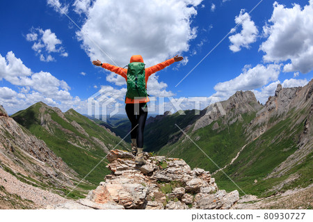 Successful woman backpacker hiking on alpine mountain peak Successful woman backpacker hiking on alpine mountain peak 80930727