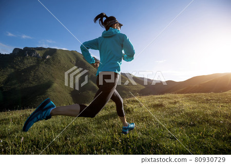 Young woman ultramarathon runner running at mountain top 80930729