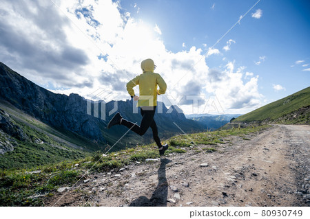Young woman ultramarathon runner running at mountain top Young woman ultramarathon runner running at mountain top 80930749