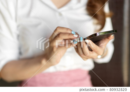 Close up, cropped shot, female worker using smartphone 80932820