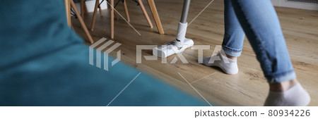 Woman cleaning floor in apartment with vacuum cleaner closeup Woman cleaning floor in apartment with vacuum cleaner closeup 80934226