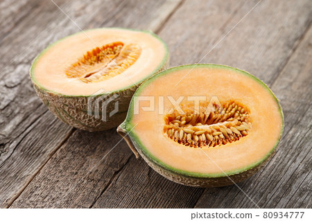 Halves of cantaloupe melon on old wooden planks Halves of cantaloupe melon on old wooden planks 80934777