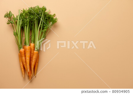 Bunch of fresh carrots on beige background 80934905