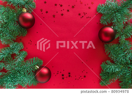 Red christmas background decorated with tree branches, glitter and baubles, winter holiday festive decorations. Merry christmas and happy 2021 New Year concept. Flat lay, top view, copy space Red christmas background decorated with tree branches, glitter and baubles, winter holiday festive decorations. Merry christmas and happy 2021 New Year concept. Flat lay, top view, copy space 80934978