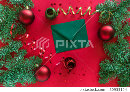 Merry Christmas happy New Year concept. Christmas composition. Christmas letter, baubles, fir tree branches on red surface. Top view Merry Christmas happy New Year concept. Christmas composition. Christmas letter, baubles, fir tree branches on red surface. Top view 80935124
