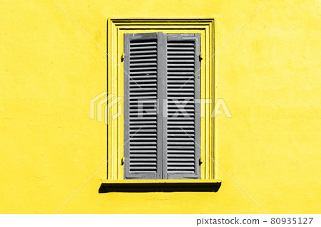 Ultimate grey and illuminating yellow. Gray shutters on the window 80935127