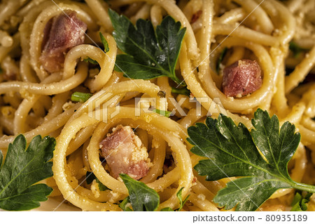 Cooked pasta carbonara with bacon pieces under egg sauce. Macro, closeup. Traditional italian kitchen cuisine. Cooked pasta carbonara with bacon pieces under egg sauce. Macro, closeup. Traditional italian kitchen cuisine. 80935189