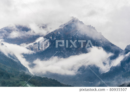 Blue foggy mountains in italian alps. Beautiful nature landscape. Autumn rain and fog on the mountain hills. Blue foggy mountains in italian alps. Beautiful nature landscape. Autumn rain and fog on the mountain hills. 80935507