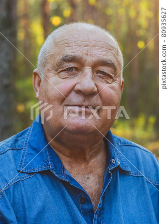 Portrait of a happy elderly smiling senior man in a park outdoor, happy life lived Portrait of a happy elderly smiling senior man in a park outdoor, happy life lived 80935627