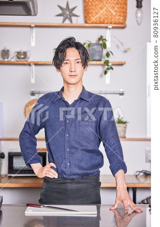 Young man standing in the kitchen with an apron Cooking boy image Young man standing in the kitchen with an apron Cooking boy image 80936127