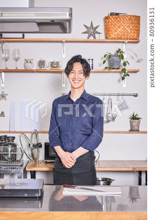 Young man standing in the kitchen with an apron Cooking boy image Young man standing in the kitchen with an apron Cooking boy image 80936131