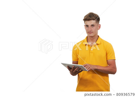young man in yellow shirt using tablet. With an isolated white background young man in yellow shirt using tablet. With an isolated white background 80936579
