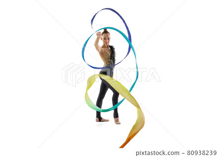 Portrait of little girl, rhythmic gymnastics artist training with colored ribbon isolated on white studio background. Concept of sport, action, aspiration 80938239