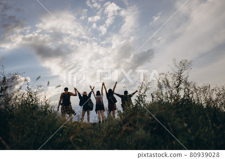 Silhouettes of people, young man and women meeting sunset outdoors, in summer forest, meadow. Active lifestyle, friendship, care, ecology concept 80939028