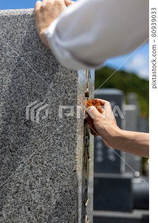 一個來掃墓的人用刷子清理墳墓 一個來掃墓的人用刷子清理墳墓 80939033