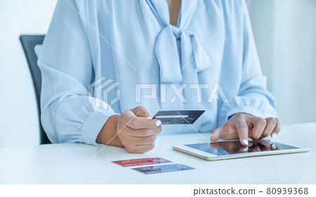 Consumer woman hand holding a mock up credit card, ready to spending pay online finance shopping according to discount products via Tablet from home office Consumer woman hand holding a mock up credit card, ready to spending pay online finance shopping according to discount products via Tablet from home office 80939368