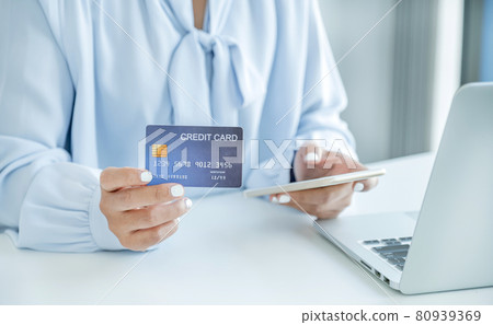 Consumer woman hand holding a mock up credit card, ready to spending pay online finance shopping according to discount products via smart phone from home office Consumer woman hand holding a mock up credit card, ready to spending pay online finance shopping according to discount products via smart phone from home office 80939369