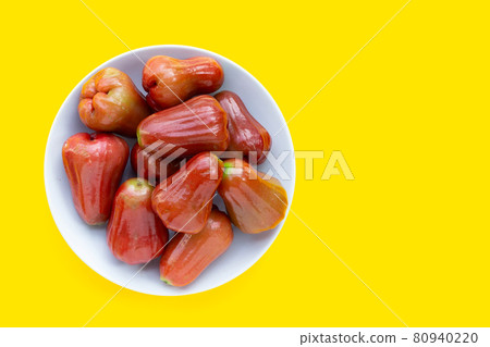 Fresh rose apple in white plate on yellow background. Fresh rose apple in white plate on yellow background. 80940220