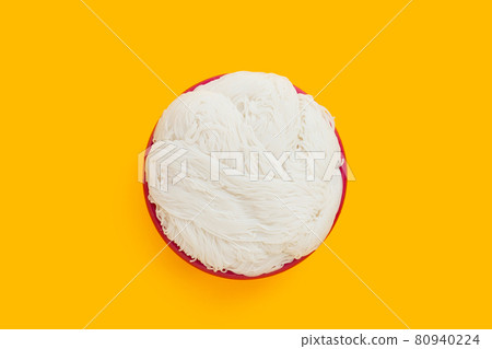 Thai rice noodle in red plastic basket on yellow background. Thai rice noodle in red plastic basket on yellow background. 80940224