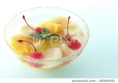 Shooting a fruit punch with various fruits and white balls on a light blue background Shooting a fruit punch with various fruits and white balls on a light blue background 80940491