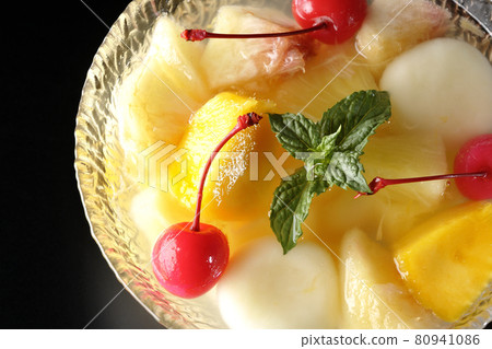 A bird's-eye view of a fruit punch containing various fruits and white balls on a black background A bird's-eye view of a fruit punch containing various fruits and white balls on a black background 80941086