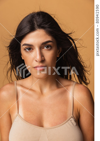 Close-up portrait of young beautiful arabian woman without makeup isolated over caramel color studio background. Natural beauty concept. Close-up portrait of young beautiful arabian woman without makeup isolated over caramel color studio background. Natural beauty concept. 80941590