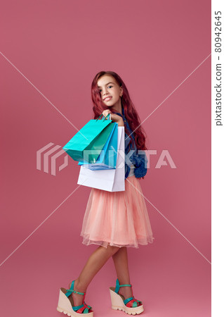 little caucasian child girl holds shopping bags 80942645