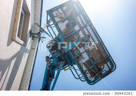 Worker on a aerial access platform, cherry picker, cleaning house Worker on a aerial access platform, cherry picker, cleaning house 80943261
