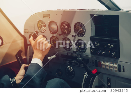 Pilot hand or private flight captain control airplane with many aircraft gauge in cockpit dashboard. 80943345