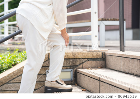 Senior woman stairs knee pain 80943519
