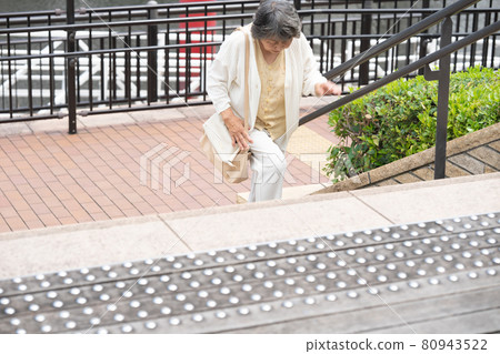 Senior woman stairs knee pain 80943522